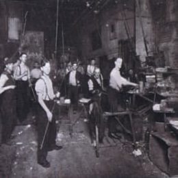 a black and white photo showing employees in a glass bottle factory