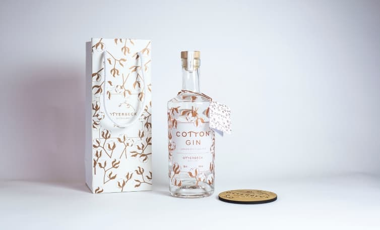 Picture of Cotton Gin Bottle by Otterbeck Distillery. Glass bottle made by Verallia. Bottle features floral printed design.